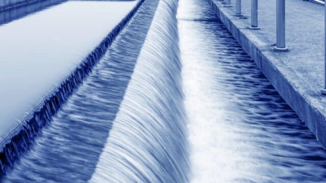 Modern urban wastewater treatment plant with water flowing down a banking.